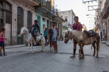 Havana, Küba - 27 Mayıs 2019: Eski Havana Şehrinin sokaklarında küçük bir atla genç Kübalı çocuklar, Küba'nın başkenti, parlak ve güneşli bir akşam.