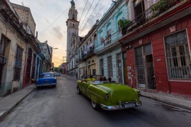 Havana, Küba - 17 Mayıs 2019: Klasik Eski Amerikan Arabası, canlı bir gün batımı nda Eski Havana Şehrinin sokaklarında.