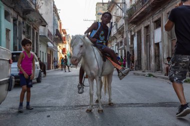 Havana, Küba - 27 Mayıs 2019: Eski Havana Şehrinin sokaklarında küçük bir atla genç Kübalı çocuklar, Küba'nın başkenti, parlak ve güneşli bir akşam.