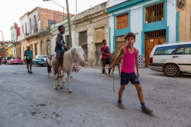 Havana, Küba - 27 Mayıs 2019: Eski Havana Şehrinin sokaklarında küçük bir atla genç Kübalı çocuklar, Küba'nın başkenti, parlak ve güneşli bir akşam.