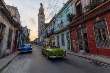 Havana, Küba - 17 Mayıs 2019: Klasik Eski Amerikan Arabası, canlı bir gün batımı nda Eski Havana Şehrinin sokaklarında.