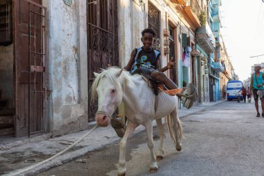 Havana, Küba - 27 Mayıs 2019: Eski Havana Şehrinin sokaklarında küçük bir atla genç Kübalı çocuklar, Küba'nın başkenti, parlak ve güneşli bir akşam.