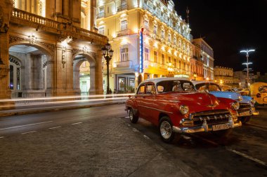 Havana, Küba - 17 Mayıs 2019: Gün batımından sonra canlı bir gece boyunca Eski Havana Şehrinin sokaklarında Klasik Eski Amerikan Arabası.