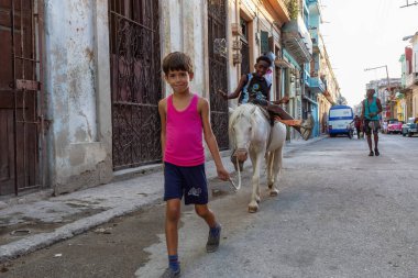 Havana, Küba - 27 Mayıs 2019: Eski Havana Şehrinin sokaklarında küçük bir atla genç Kübalı çocuklar, Küba'nın başkenti, parlak ve güneşli bir akşam.