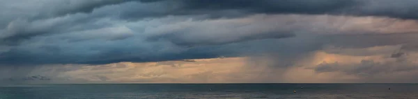 Dramatic View of a cloudscape over the Ocean during a dark, rainy and colorful morning sunrise. Taken over Beach Ancon in Trinidad, Cuba.