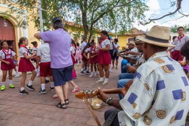 Trinidad, Küba - 6 Haziran 2019: İnsanlar canlı güneşli bir günde küçük bir Küba Kasabasının sokaklarında canlı müzik eşliğinde dans ediyorlar.
