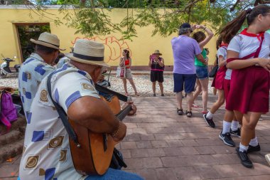 Trinidad, Küba - 6 Haziran 2019: İnsanlar canlı güneşli bir günde küçük bir Küba Kasabasının sokaklarında canlı müzik eşliğinde dans ediyorlar.