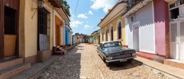 Trinidad, Küba - 6 Haziran 2019: Canlı güneşli bir günde küçük bir Küba Kasabasının sokaklarında eski bir Klasik Amerikan Arabasının Manzarası.