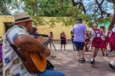 Trinidad, Küba - 6 Haziran 2019: İnsanlar canlı güneşli bir günde küçük bir Küba Kasabasının sokaklarında canlı müzik eşliğinde dans ediyorlar.