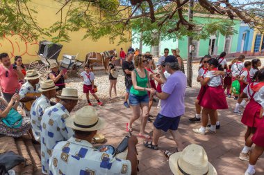 Trinidad, Küba - 6 Haziran 2019: İnsanlar canlı güneşli bir günde küçük bir Küba Kasabasının sokaklarında canlı müzik eşliğinde dans ediyorlar.