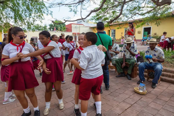 Trinidad, Küba - 6 Haziran 2019: Öğrenciler canlı güneşli bir günde küçük bir Küba Kasabası'nın sokaklarında canlı müzik eşliğinde dans ediyorlar.