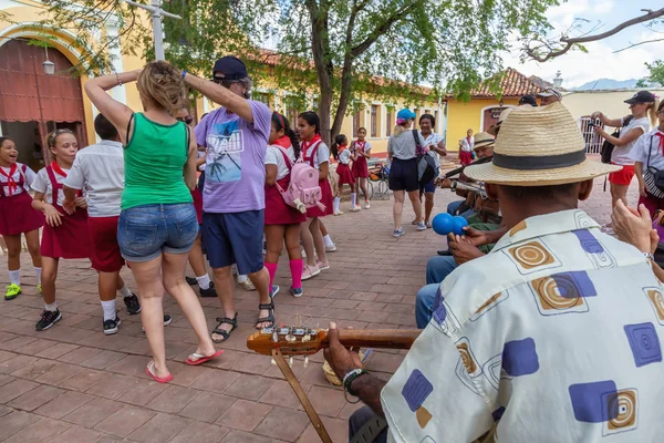 Trinidad, Küba - 6 Haziran 2019: İnsanlar canlı güneşli bir günde küçük bir Küba Kasabasının sokaklarında canlı müzik eşliğinde dans ediyorlar.