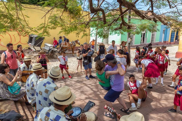 Trinidad, Küba - 6 Haziran 2019: İnsanlar canlı güneşli bir günde küçük bir Küba Kasabasının sokaklarında canlı müzik eşliğinde dans ediyorlar.