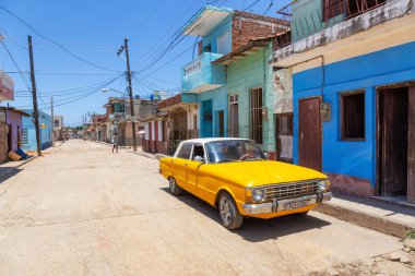 Trinidad, Cuba - June 6, 2019: View of an Old Classic American Car in the streets of a small Cuban Town during a vibrant sunny day. clipart
