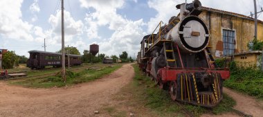 Trinidad, Küba - 08 Haziran 2019: Güneşli ve bulutlu bir günde eski bir trenle terk edilmiş bir tren istasyonunun görünümü.