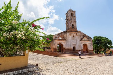Trinidad, Küba - 6 Haziran 2019: Canlı güneşli bir günde küçük bir turistik Küba Kasabasında eski bir kilisenin Sokak Görünümü.
