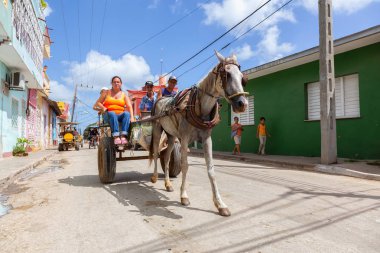 Trinidad, Küba - 8 Haziran 2019: Canlı güneşli bir günde küçük bir Küba Kasabasının sokaklarında At Arabası.