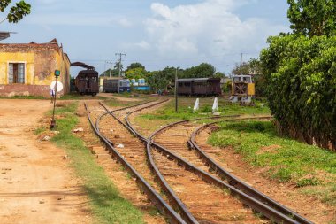 Güneşli ve bulutlu bir günde eski bir tren ile Terk edilmiş bir tren istasyonu görünümü. Trinidad, Küba'da çekilmiş.