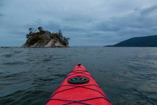 Sea Kayaking in the Howe Sound during a cloudy sunset. Taken in Horseshoe Bay, West Vancouver, BC, Canada.