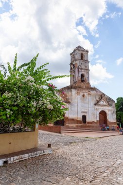 Trinidad, Küba - 6 Haziran 2019: Canlı güneşli bir günde küçük bir turistik Küba Kasabasında eski bir kilisenin Sokak Görünümü.