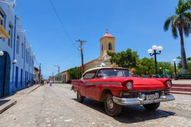 Trinidad, Küba - 6 Haziran 2019: Canlı güneşli bir günde küçük bir Küba Kasabasının sokaklarında eski bir Klasik Amerikan Arabasının Manzarası.