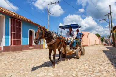 Trinidad, Küba - 6 Haziran 2019: Canlı güneşli bir günde küçük bir Küba Kasabasının sokaklarında At Arabası.