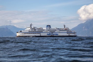 Batı Vancouver, British Columbia, Kanada - 21 Nisan 2019: Güneşli ve bulutlu bir günde Horseshoe Bay Terminali'nden ayrılan Bc Ferries Boat'ın su perspektifinden görünümü.