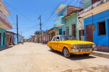 Trinidad, Küba - 6 Haziran 2019: Canlı güneşli bir günde küçük bir Küba Kasabasının sokaklarında eski bir Klasik Amerikan Arabasının Manzarası.