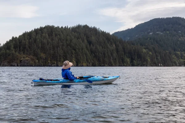 Kayıktaki maceracı adam bulutlu bir akşam da Howe Sound'da kürek çekiyor. Bowen Adası yakınlarında çekilen, Vancouver'ın kuzeybatısında, Bc, Kanada.