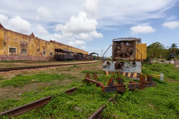 Güneşli ve bulutlu bir günde eski bir tren ile Terk edilmiş bir tren istasyonu görünümü. Trinidad, Küba'da çekilmiş.