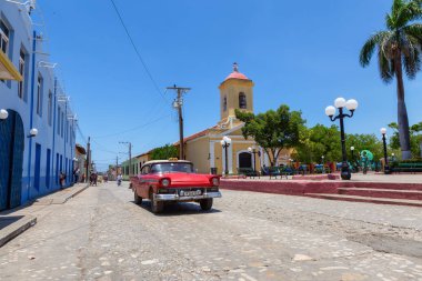 Trinidad, Küba - 6 Haziran 2019: Canlı güneşli bir günde küçük bir Küba Kasabasının sokaklarında eski bir Klasik Amerikan Arabasının Manzarası.
