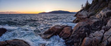 Canlı güneşli bir gün batımı sırasında kayalık bir okyanus sahilinin güzel Panoramik manzarası. Lighthouse Park, Horseshoe Bay, West Vancouver, British Columbia, Kanada'da çekilmiş.