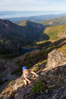 Maceracı kız canlı bir yaz akşamı sırasında Kanada Dağ Manzara dik bir uçuruma tırmanma. Mt Arrowsmith'te, Nanaimo yakınlarında, Vancouver Adası, Bc, Kanada.