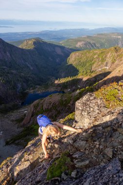 Maceracı kız canlı bir yaz akşamı sırasında Kanada Dağ Manzara dik bir uçuruma tırmanma. Mt Arrowsmith'te, Nanaimo yakınlarında, Vancouver Adası, Bc, Kanada.