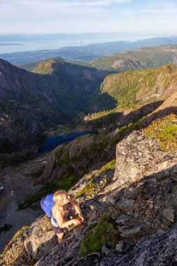 Maceracı kız canlı bir yaz akşamı sırasında Kanada Dağ Manzara dik bir uçuruma tırmanma. Mt Arrowsmith'te, Nanaimo yakınlarında, Vancouver Adası, Bc, Kanada.
