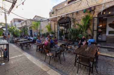 Yafa, Tel Aviv, İsrail - 13 Nisan 2019: Güneşli bir akşamda Eski Yafa Şehri'nde dışarıda akşam yemeği içen insanlar.
