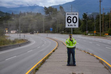 Squamish, British Columbia, Kanada - 26 Temmuz 2019: Fake Cardboard Cutout Polis Memuru şehre müdahale etmeden önce Sea to Sky Highway'de hız tabancası tutuyor.