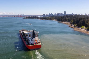 Arka planda Downtown City ile Stanley Park tarafından geçen bir Büyük Konteyner Gemi Havadan Görünümü. Lions Gate Bridge, Vancouver, British Columbia, Kanada'dan alınmıştır.