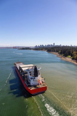 Arka planda Downtown City ile Stanley Park tarafından geçen bir Büyük Konteyner Gemi Havadan Görünümü. Lions Gate Bridge, Vancouver, British Columbia, Kanada'dan alınmıştır.