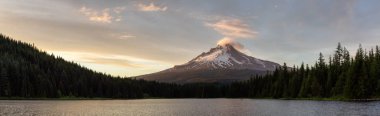 Beautiful Panoramic Landscape View of Mt Hood during a dramatic cloudy sunset. Taken from Trillium Lake, Mt. Hood National Forest, Oregon, United States of America. clipart