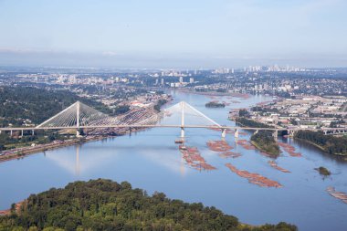 Canlı bir yaz sabahı Fraser Nehri ve Port Mann Köprüsü'nün havadan görünümü. Greater Vancouver, British Columbia, Kanada'da çekildi.