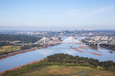Canlı bir yaz sabahı Fraser Nehri ve Port Mann Köprüsü'nün havadan görünümü. Greater Vancouver, British Columbia, Kanada'da çekildi.