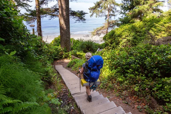 Adventurous female is hiking Juan de Fuca Trail to Mystic Beach on the Pacific Ocean Coast during a sunny summer day. Taken near Port Renfrew, Vancouver Island, BC, Canada.