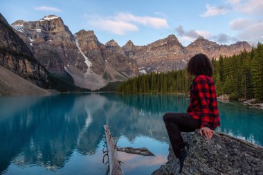 Canlı bir yaz gün doğumu sırasında Bir Iconic Famous Place, Moraine Gölü, güzel bir manzaranın tadını çıkaran kız. Banff National Park, Alberta, Kanada'da bulunan.