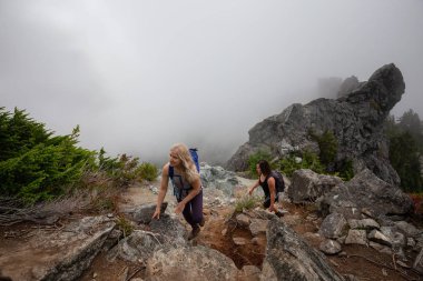 Maceracı Kız bulutlu bir yaz sabahı boyunca güzel bir kayalık dağ kadar dik bir iz kadar yürüyüş olduğunu. Crown Mountain'da çekilmiş, Kuzey Vancouver, Bc, Kanada.