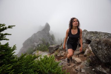 Maceracı Kız bulutlu bir yaz sabahı boyunca güzel bir kayalık dağ kadar dik bir iz kadar yürüyüş olduğunu. Crown Mountain'da çekilmiş, Kuzey Vancouver, Bc, Kanada.