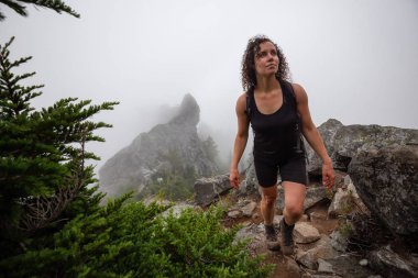 Maceracı Kız bulutlu bir yaz sabahı boyunca güzel bir kayalık dağ kadar dik bir iz kadar yürüyüş olduğunu. Crown Mountain'da çekilmiş, Kuzey Vancouver, Bc, Kanada.