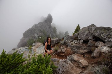 Maceracı Kız bulutlu bir yaz sabahı boyunca güzel bir kayalık dağ kadar dik bir iz kadar yürüyüş olduğunu. Crown Mountain'da çekilmiş, Kuzey Vancouver, Bc, Kanada.