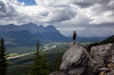 Maceracı Kız bulutlu ve yağmurlu bir gün boyunca kayalık bir dağkadar yürüyüş olduğunu. Lady Macdonald, Canmore, Alberta, Kanada'dan alındı.