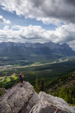 Maceracı Kız bulutlu ve yağmurlu bir gün boyunca kayalık bir dağın tepesinde fotoğraf çekmek. Lady Macdonald, Canmore, Alberta, Kanada'dan alındı.